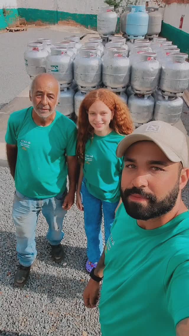 Equipe real da SJ Gás no pátio da distribuidora, com botijões empilhados ao fundo.